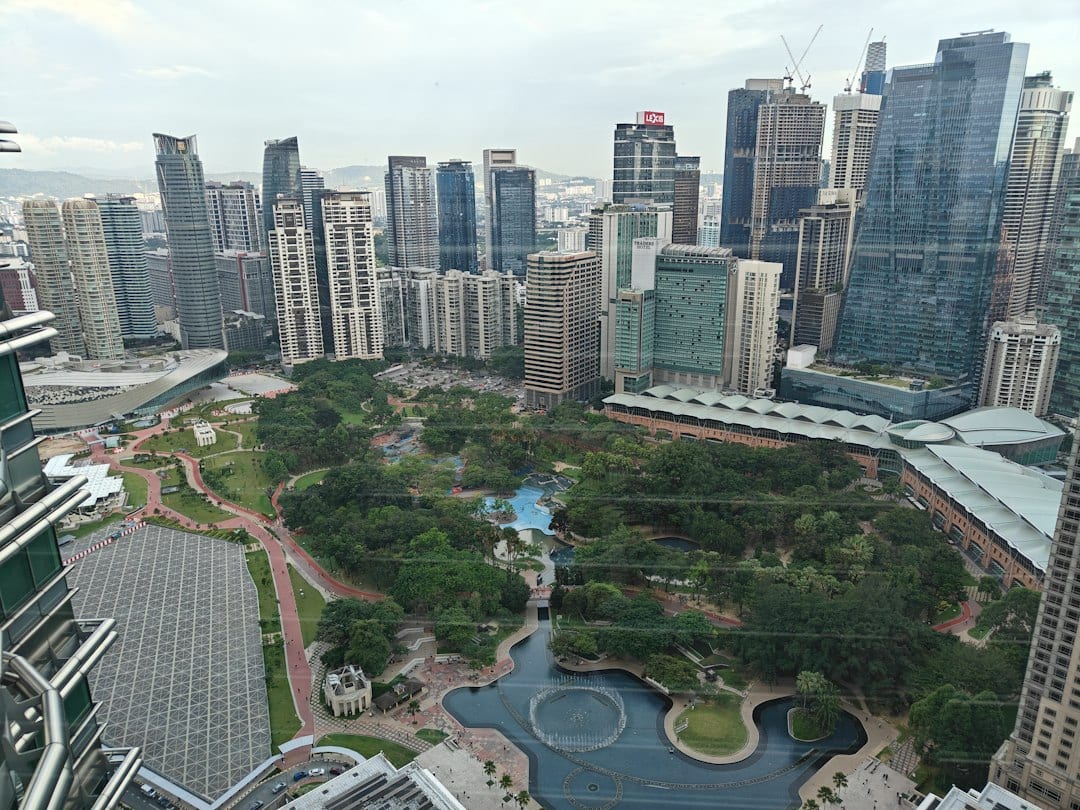 Aerial view of city park surrounded by modern skyscrapers